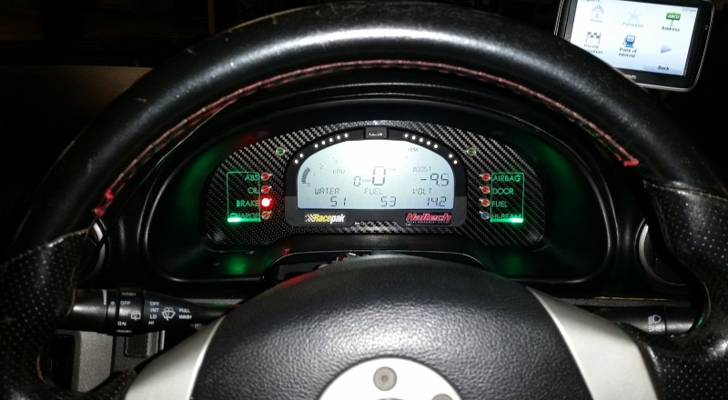 A Custom Cluster with a Racepak IQ3 Display installed in a Nissan S15 Sivia 200sx with Green LED illumination Front on