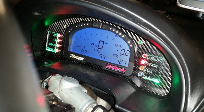 A Custom Cluster with a Racepak IQ3 Display installed in a Nissan S15 Sivia 200sx with Green LED illumination with flash