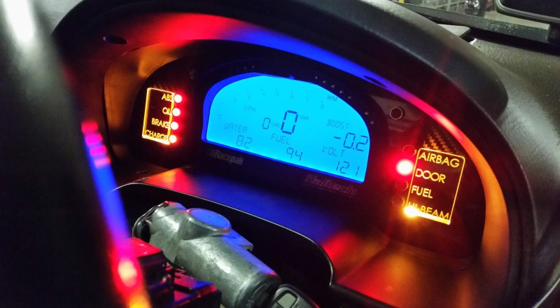 A Custom Cluster with a Racepak IQ3 Display installed in a Nissan S15 Sivia 200sx with Amber LED illumination