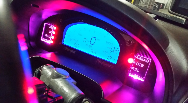 A Custom Cluster with a Racepak IQ3 Display installed in a Nissan S15 Sivia 200sx with Pink LED illumination